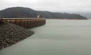 The shore of Lake Shasta behind Shasta Dam in Lake Shasta, Calif., is seen Sunday, March 13, 2016. The lake's water level has been rising after a series of storms brought strong winds, periods of heavy rain, snow and high surf to California Sunday, the fourth straight day of wet weather. The lake is rising after several years of dropping water levels due to the ongoing California drought. (Nathan Solis/The Record Searchlight via AP)