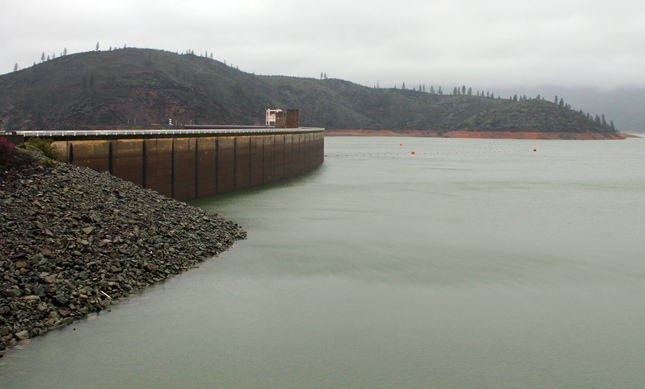 The shore of Lake Shasta behind Shasta Dam in Lake Shasta, Calif., is seen Sunday, March 13, 2016. The lake's water level has been rising after a series of storms brought strong winds, periods of heavy rain, snow and high surf to California Sunday, the fourth straight day of wet weather. The lake is rising after several years of dropping water levels due to the ongoing California drought. (Nathan Solis/The Record Searchlight via AP)