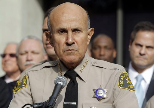 FILE - In this Jan. 7, 2014, file photo, Los Angeles County Sheriff Lee Baca announces his retirement at a news conference at Sheriff's Headquarters Bureau in Monterey Park, Calif. Baca signed a plea agreement that said he ordered deputies to intimidate an FBI agent and "do everything but put handcuffs on her." Baca, who pleaded guilty to trying to thwart an FBI investigation into abuses at the jails he ran, is in the early stages of Alzheimer's and must decide whether he spends the best remaining days of his life fighting to stay out of jail or behind bars. (AP Photo/Nick Ut, File)